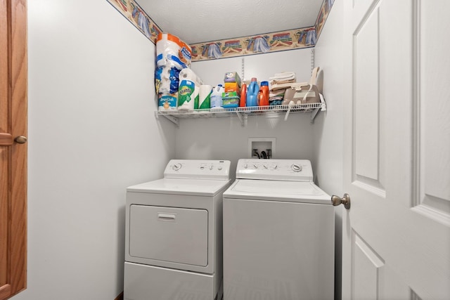 laundry area featuring washer and clothes dryer and a textured ceiling