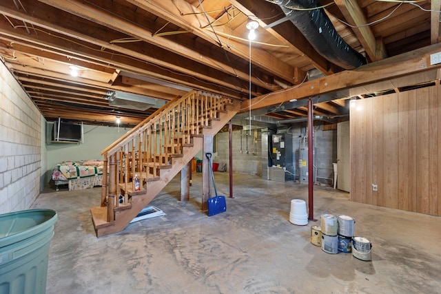 unfinished below grade area with water heater, heating unit, and stairs