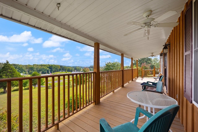 wooden deck featuring ceiling fan, a yard, and covered porch