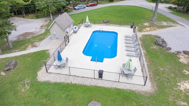 view of pool featuring an outbuilding, a garage, and a lawn