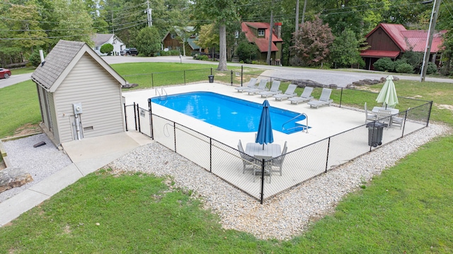 view of swimming pool featuring a yard