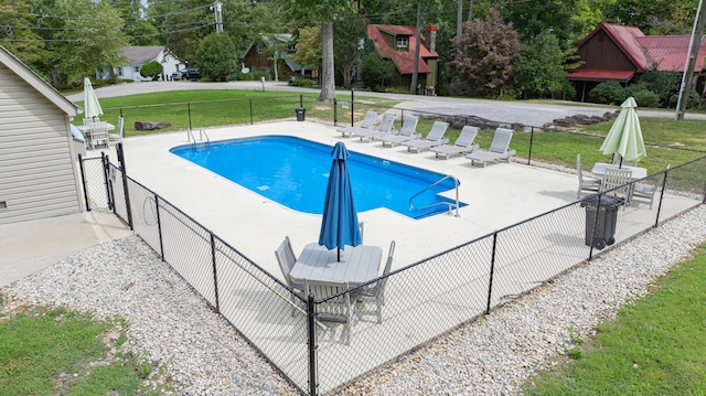 view of pool with a lawn and a patio