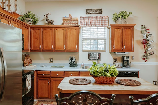 kitchen with black appliances, sink, and wood counters