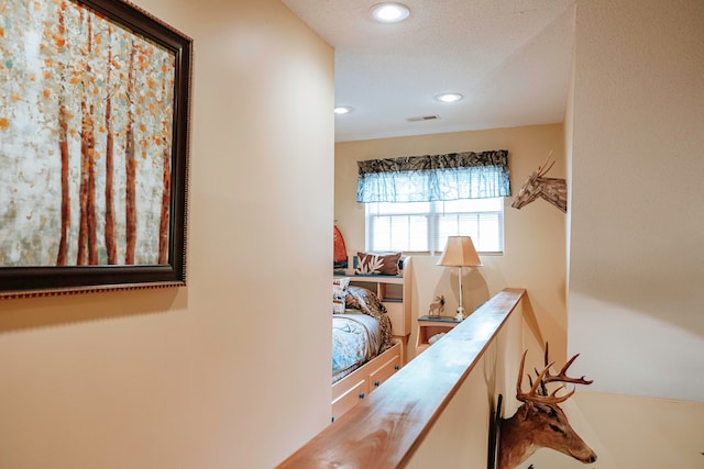 hall with a textured ceiling