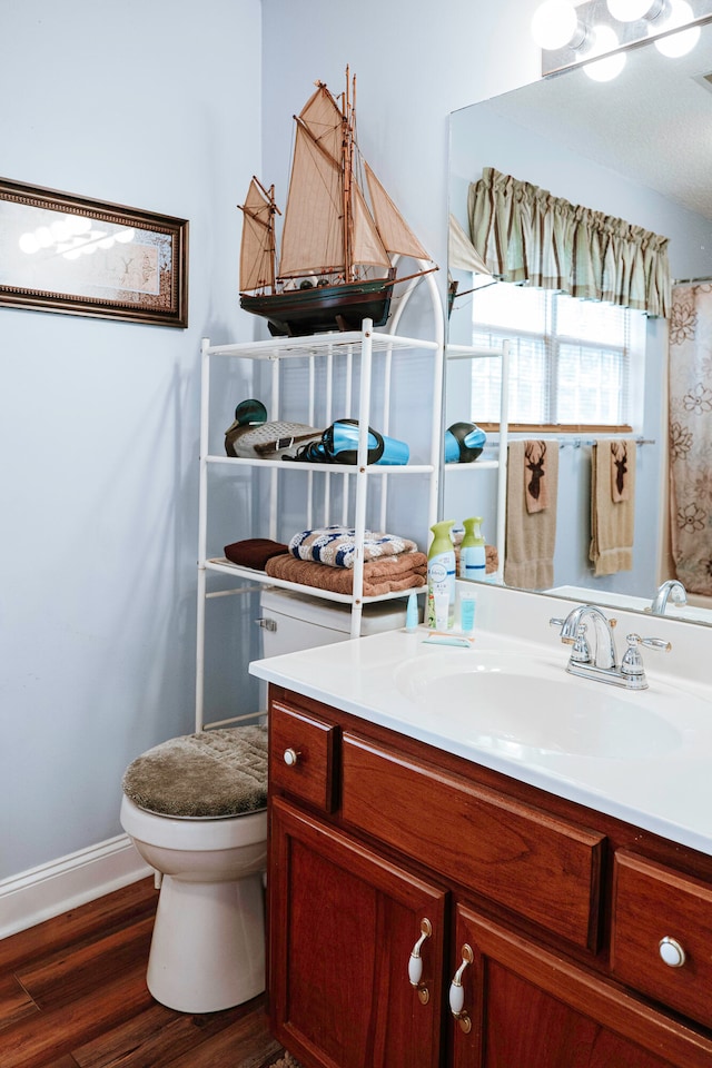 bathroom with vanity, toilet, and hardwood / wood-style flooring