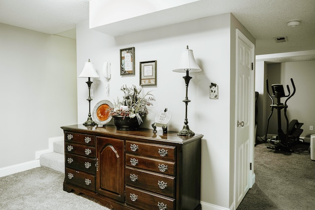 corridor featuring a textured ceiling and carpet floors