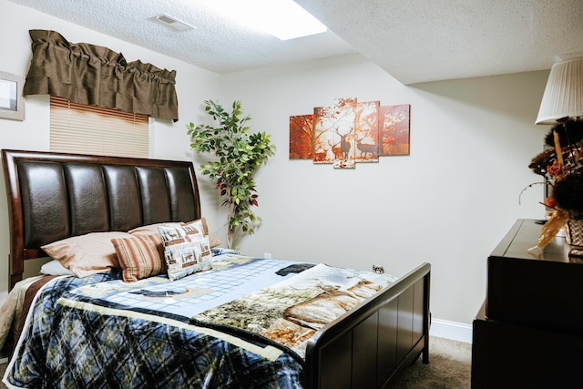 bedroom featuring a textured ceiling and dark colored carpet