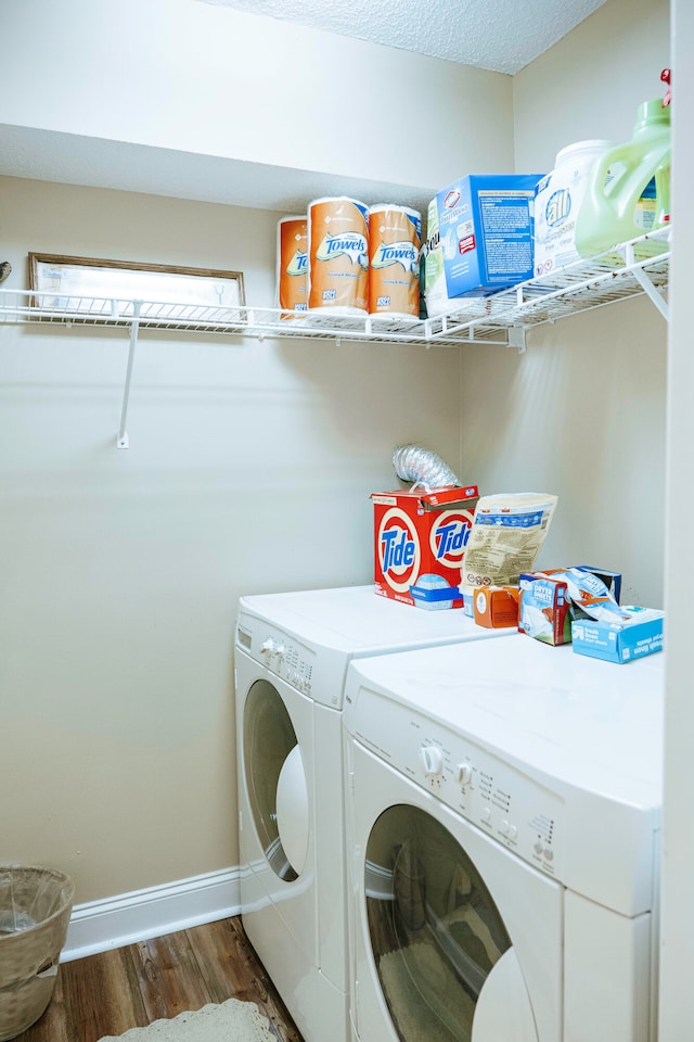 laundry room featuring a textured ceiling, dark wood-type flooring, and independent washer and dryer