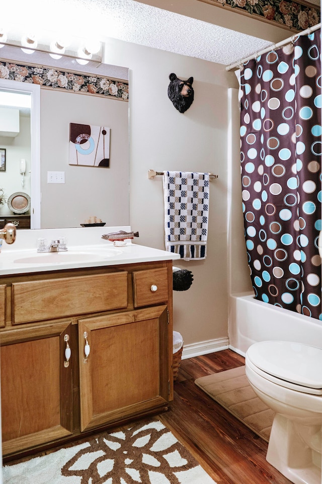 full bathroom with toilet, vanity, a textured ceiling, shower / bath combo with shower curtain, and hardwood / wood-style flooring