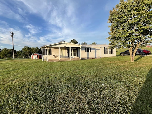 rear view of property featuring a porch and a lawn