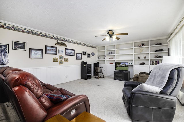 carpeted living room featuring ceiling fan, built in features, and a textured ceiling