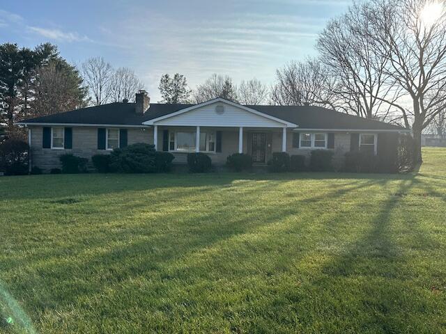 ranch-style house with covered porch and a front lawn