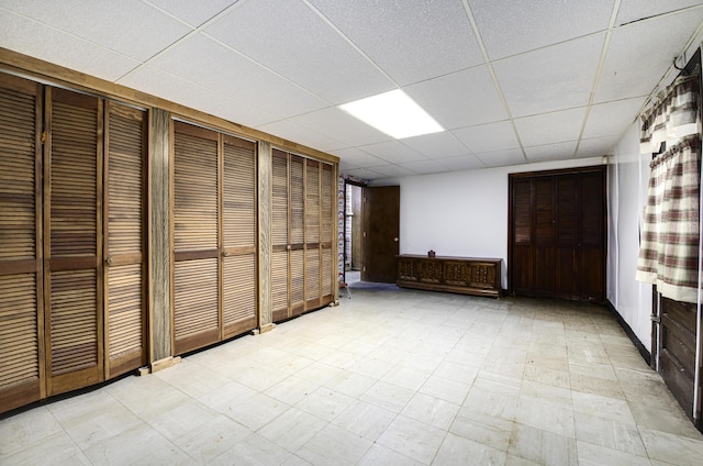 unfurnished bedroom with a paneled ceiling and two closets