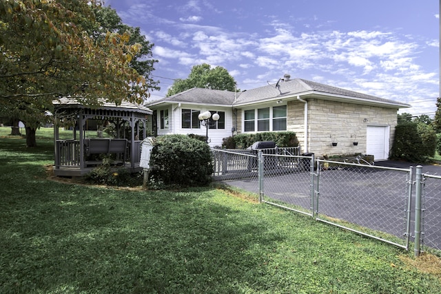 view of property exterior with a gazebo, a lawn, stone siding, an attached garage, and a gate