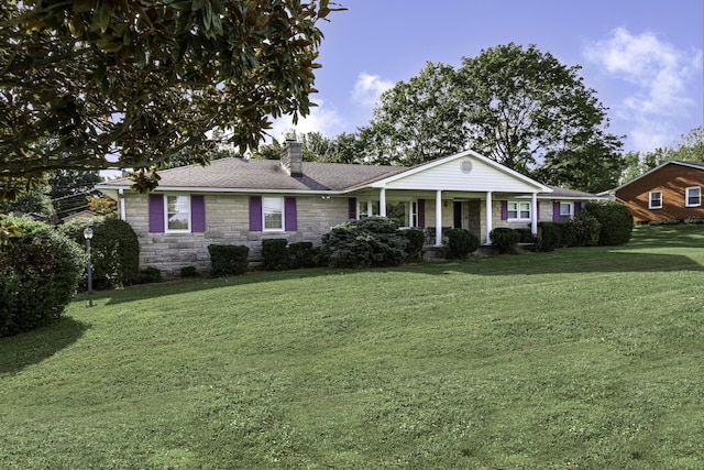 ranch-style home featuring stone siding, covered porch, roof with shingles, a front yard, and a chimney