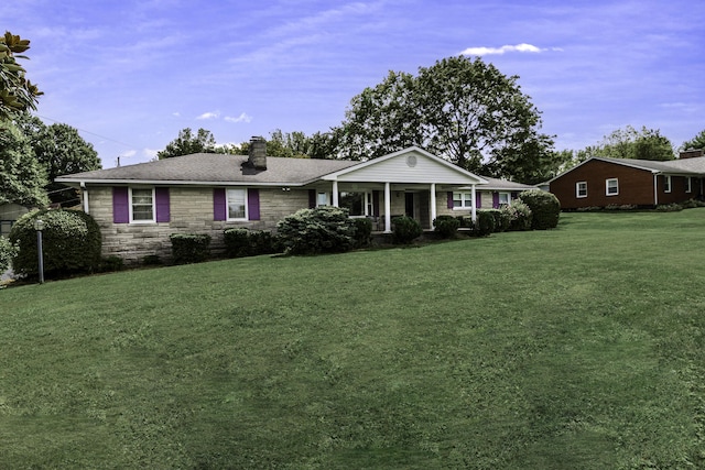 ranch-style home featuring a front yard, covered porch, stone siding, and a chimney