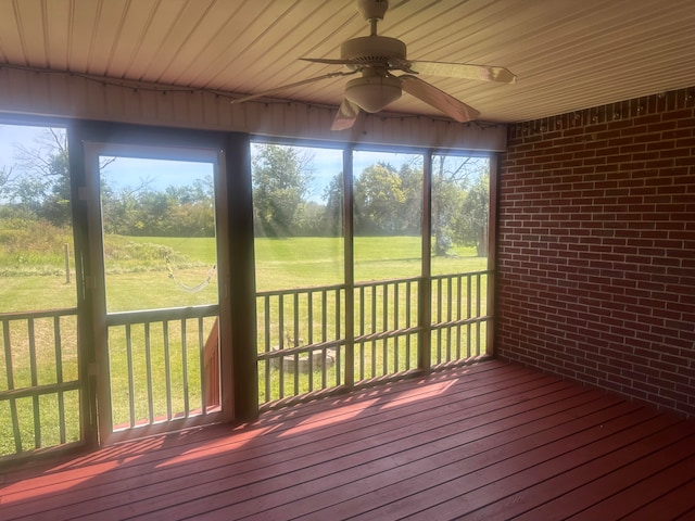 unfurnished sunroom featuring wood ceiling and ceiling fan