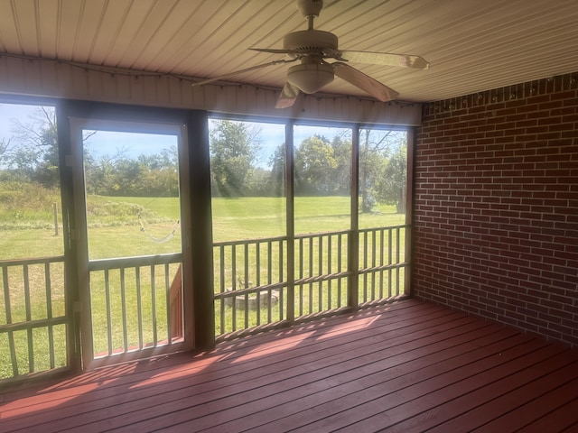unfurnished sunroom featuring a ceiling fan