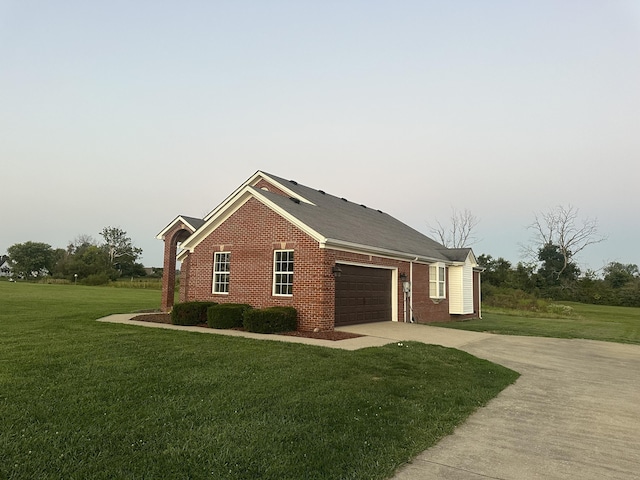 view of property exterior with a yard, brick siding, an attached garage, and driveway