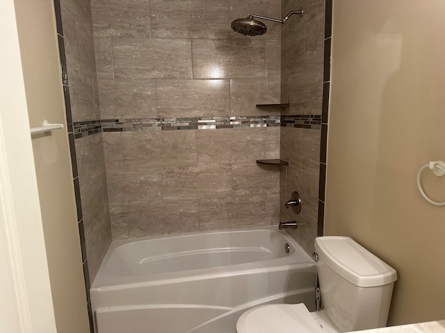 bathroom featuring tiled shower / bath combo and toilet