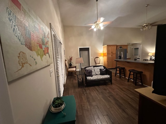 living room with dark hardwood / wood-style floors, ceiling fan, and high vaulted ceiling