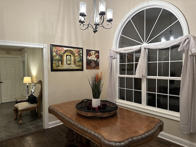 dining area featuring baseboards, dark wood-style flooring, and a chandelier