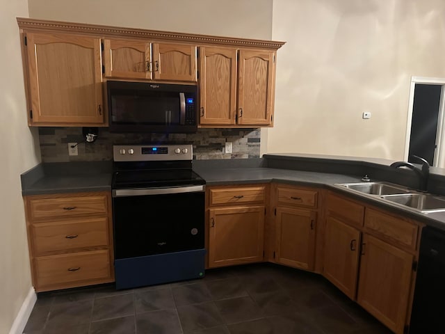 kitchen with dark tile patterned floors, sink, tasteful backsplash, and black appliances