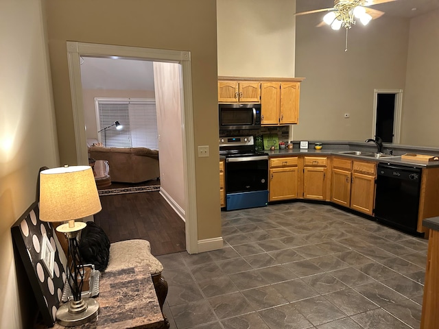 kitchen featuring ceiling fan, sink, stainless steel appliances, a towering ceiling, and decorative backsplash