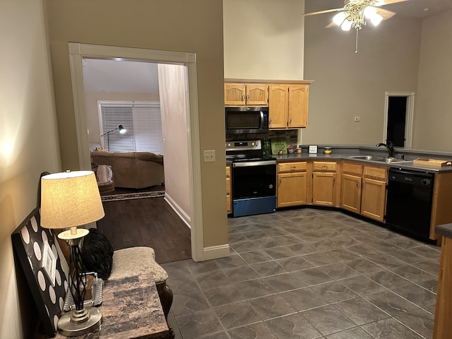 kitchen featuring a ceiling fan, dark countertops, a sink, light brown cabinets, and stainless steel appliances