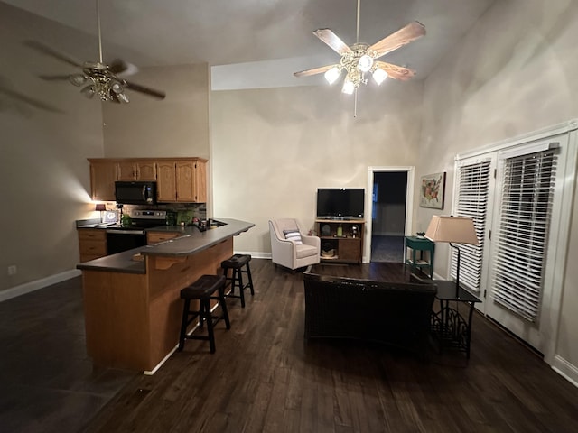 living area featuring dark wood-type flooring, baseboards, ceiling fan, and high vaulted ceiling