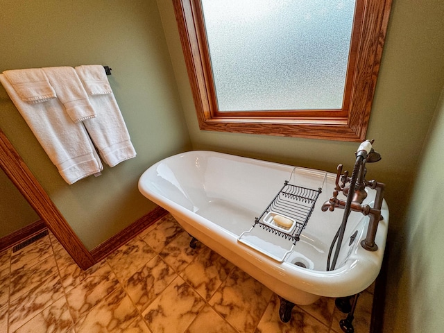 bathroom with a tub to relax in and tile patterned flooring