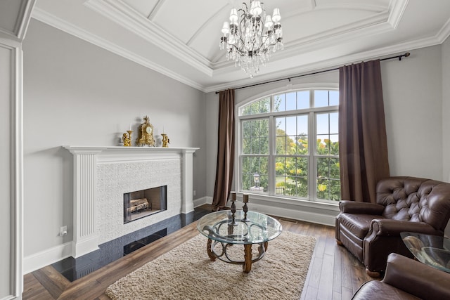 living room with a tray ceiling, a chandelier, dark hardwood / wood-style flooring, and crown molding