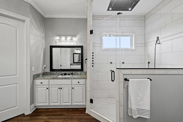 bathroom featuring crown molding, vanity, hardwood / wood-style flooring, and a shower with shower door