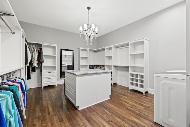 walk in closet with dark wood-type flooring, a chandelier, and washer / clothes dryer