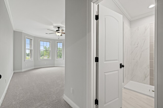 hallway featuring crown molding and light carpet