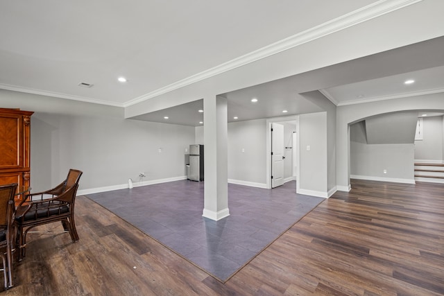 basement featuring dark hardwood / wood-style flooring, stainless steel refrigerator, and ornamental molding