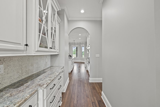 corridor featuring ornamental molding and dark hardwood / wood-style flooring