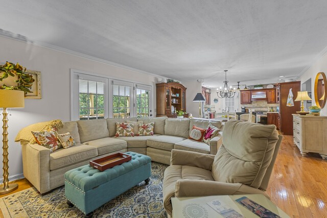 living room featuring an inviting chandelier, light wood-type flooring, and crown molding