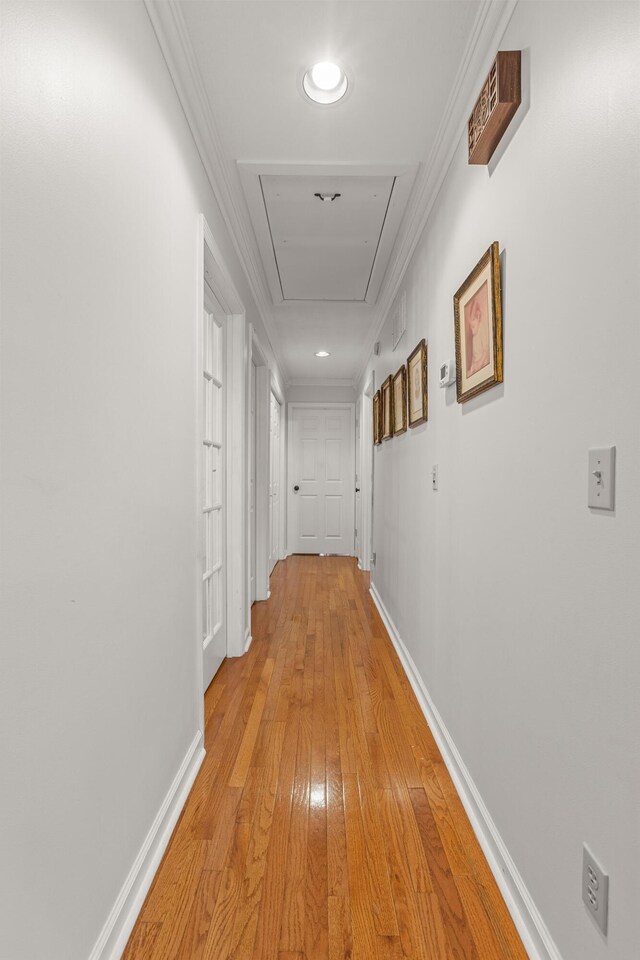 corridor featuring light hardwood / wood-style flooring and crown molding