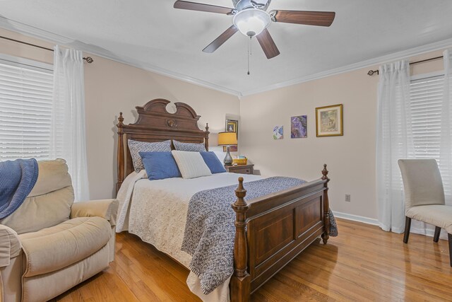 bedroom with ceiling fan, light wood-type flooring, crown molding, and multiple windows