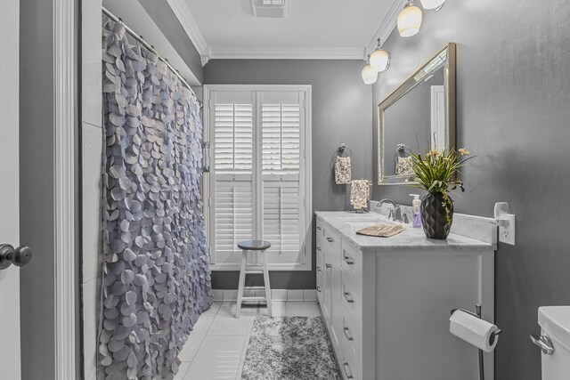 bathroom with ornamental molding, vanity, toilet, and tile patterned floors