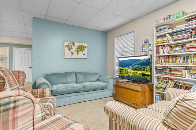 living room featuring carpet flooring and a paneled ceiling