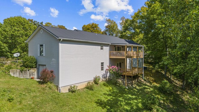 back of property with a wooden deck and a yard