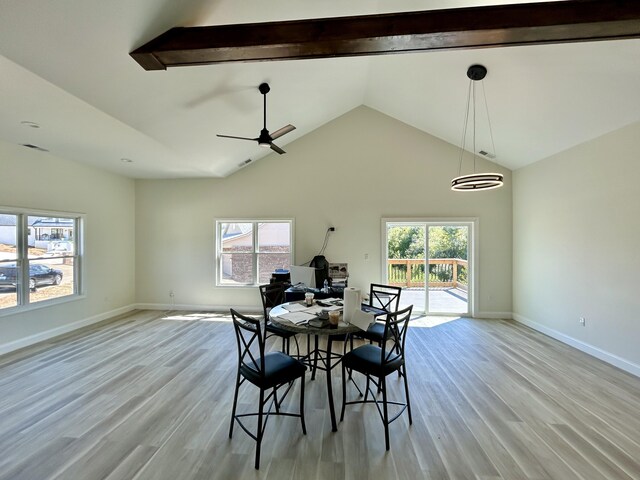 dining room with a wealth of natural light, light hardwood / wood-style flooring, beam ceiling, and ceiling fan