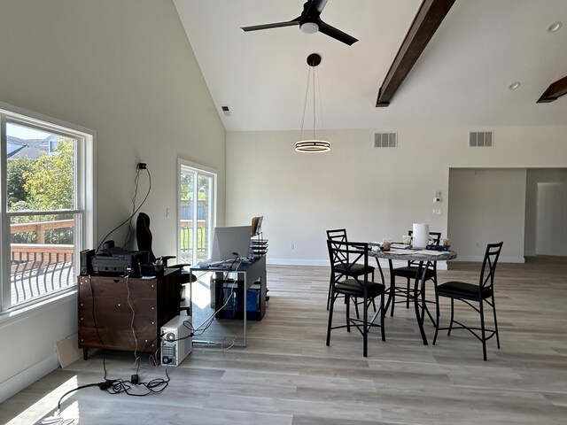 dining space with light wood-type flooring, ceiling fan, beamed ceiling, and a healthy amount of sunlight