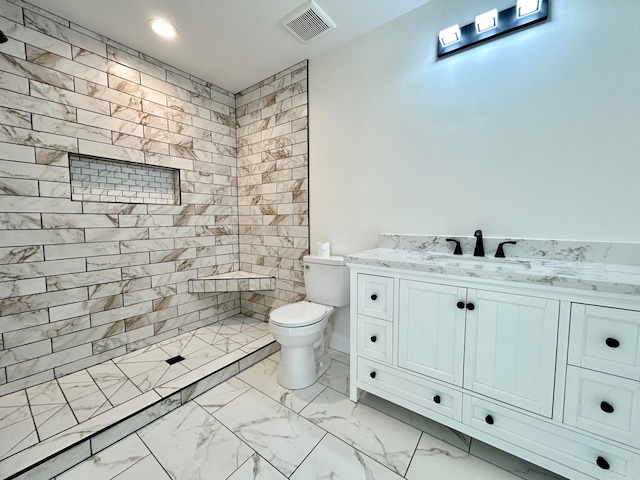 bathroom featuring vanity, toilet, and tiled shower