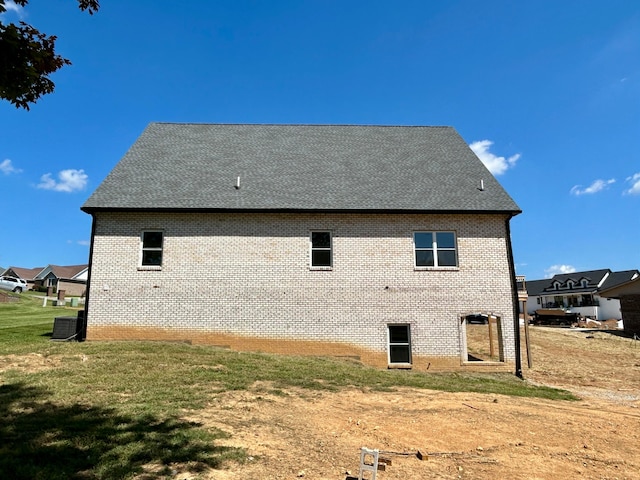 view of side of home featuring a yard and central AC unit