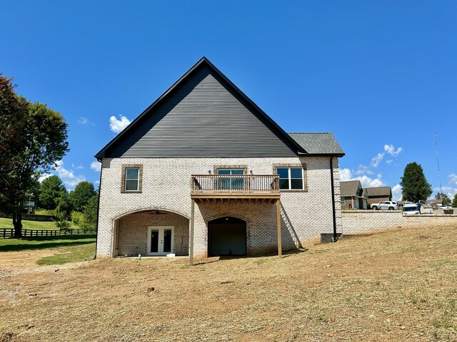 rear view of property featuring a lawn and a wooden deck