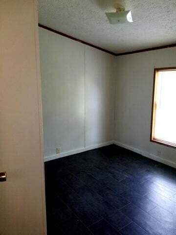 spare room with a textured ceiling and crown molding