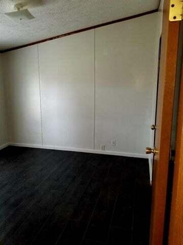 unfurnished room featuring a textured ceiling, crown molding, and hardwood / wood-style floors